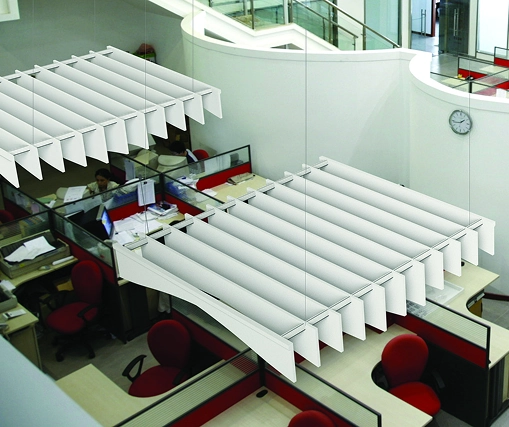 A spacious open office featuring a large window and acoustic suspended ceilings for sound absorption